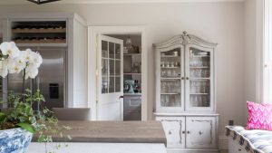 6 pièces intemporelles de la cuisine de votre grand-mère que vous allez vouloir garder Dining room with antique cabinet holding glassware, looking into kitchen with shelves of china and blue mixer