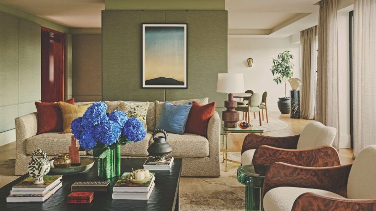 Comment utiliser la texture dans la conception d’intérieur – 7 façons dont les concepteurs utilisent des matériaux et des finitions pour ajouter de l’intérêt à n’importe quel espace living roo with green walls and sofa and two burl edged armchairs and coffee table stacked with books