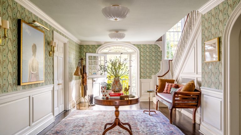 opulent entryway with round table, wallpaper and oversized art by Camden Grace Interiors