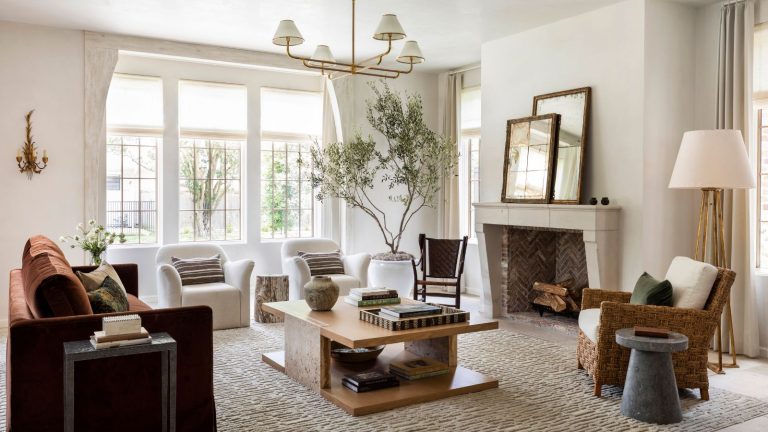 J’ai un goût de créateur sur un budget de réduction – voici les meilleurs tapis, miroirs et lumières que je fais des achats dans les ventes pour finalement terminer ma maison traditional neutral farmhouse living room by marie flanigan with a fireplace, large rustic sofa, wooden coffee table, olive tree, and two white arm chairs