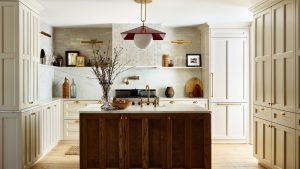 8 décisions de conception de la cuisine à prendre maintenant qui pourraient augmenter la valeur de votre maison plus tard, selon des designers d’intérieur modern rustic kitchen with wooden island, warm neutral cabinets and walls