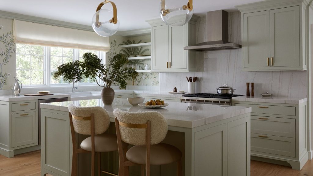 pale green kitchen with marble backsplash and floral wallpaper with island and boucle seating around