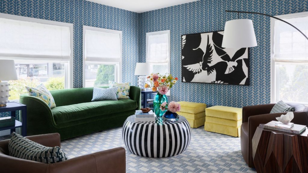 Living room with blue wallpaper, green couch and striped black and white coffee table