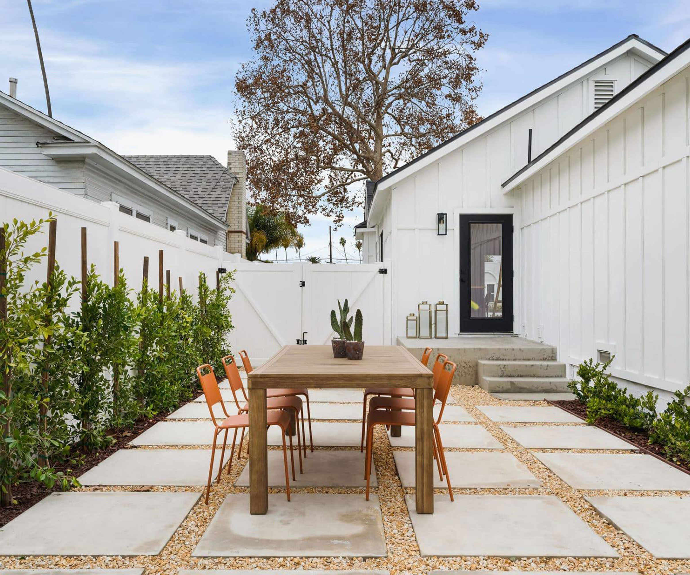 Petit patio du côté de la maison avec de grands pavés et des détails de gravier