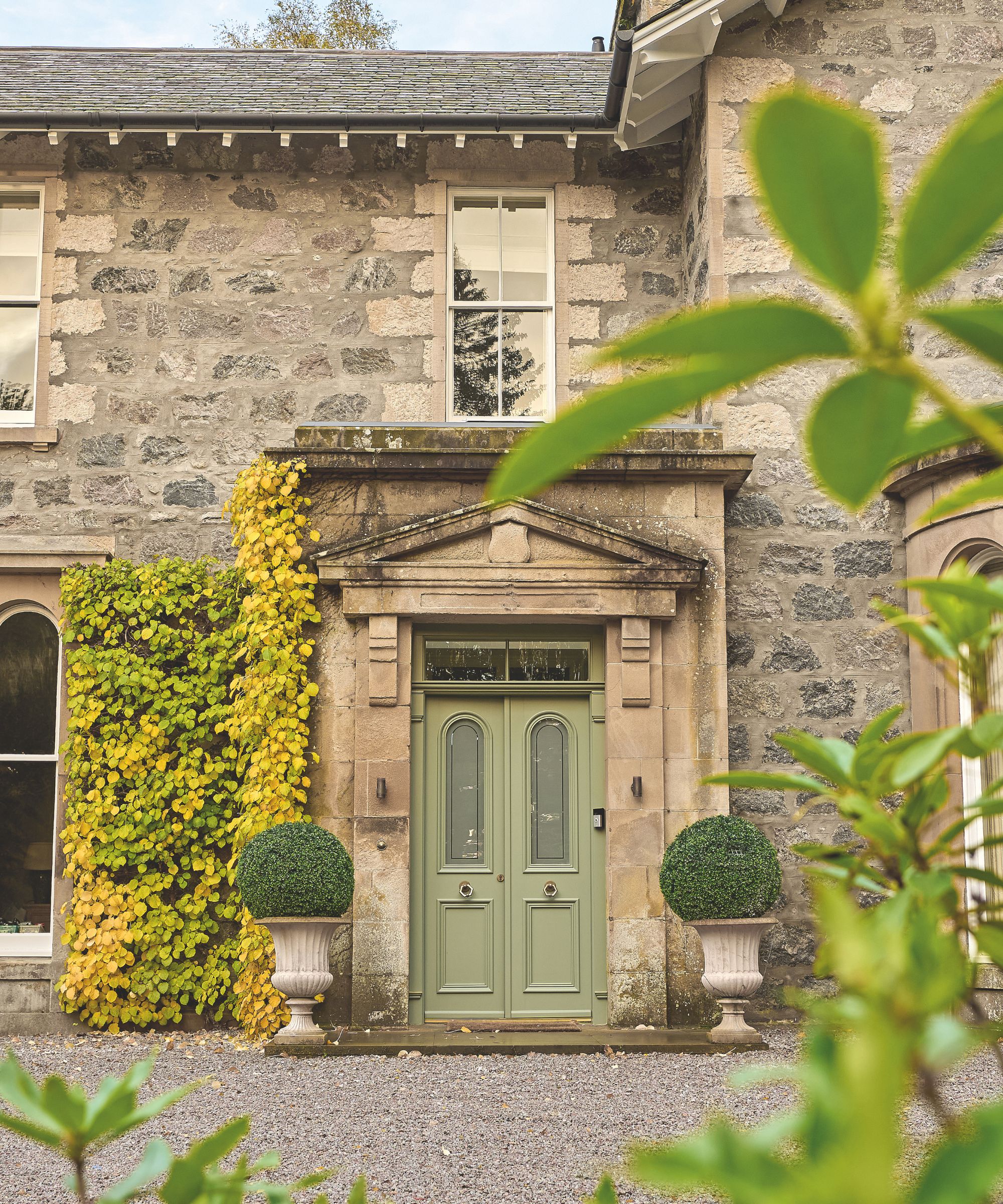 Extérieur de la maison en pierre avec porte verte pâle