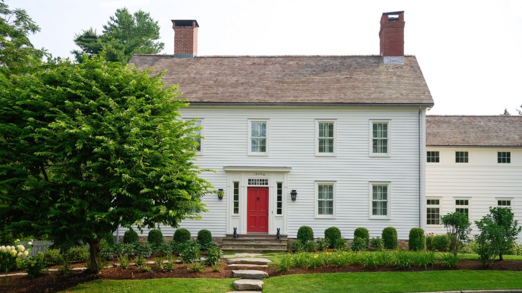 White paneled house with red door