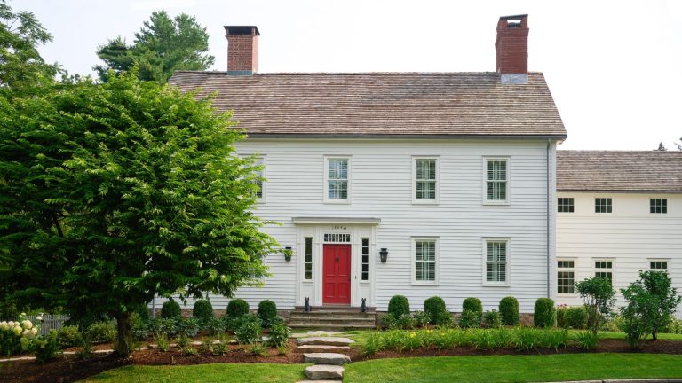 L’histoire derrière cette vieille ferme du Connecticut est comme quelque chose d’un film – les parents du designer qui le sauvent du réaménagement ne sont que le début White paneled house with red door
