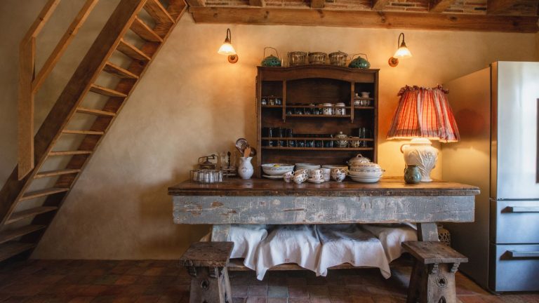 7 styles et marques de vaisselle intemporels à toujours rechercher lors de l’émission Farmhouse kitchen with beams, wall sconces, antique dresser and table with vintage china and dishes