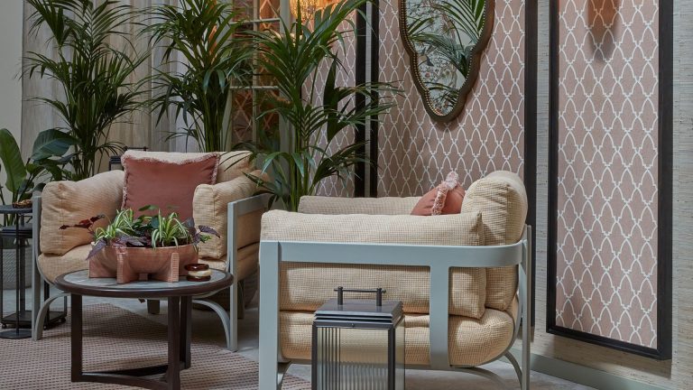 La cour d’inspiration maure à la maison WOW! À Londres de cette année est une leçon de réduction soigneusement gérée – voici comment obtenir le look A courtyard garden with two large armchairs and a coffee table, with planters and lanterns