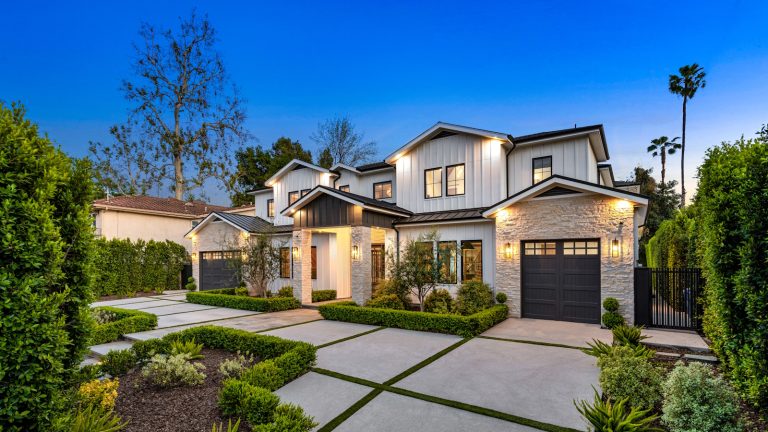 Exterior photo of a home in Beverly Hills at dusk, with neat privet planting