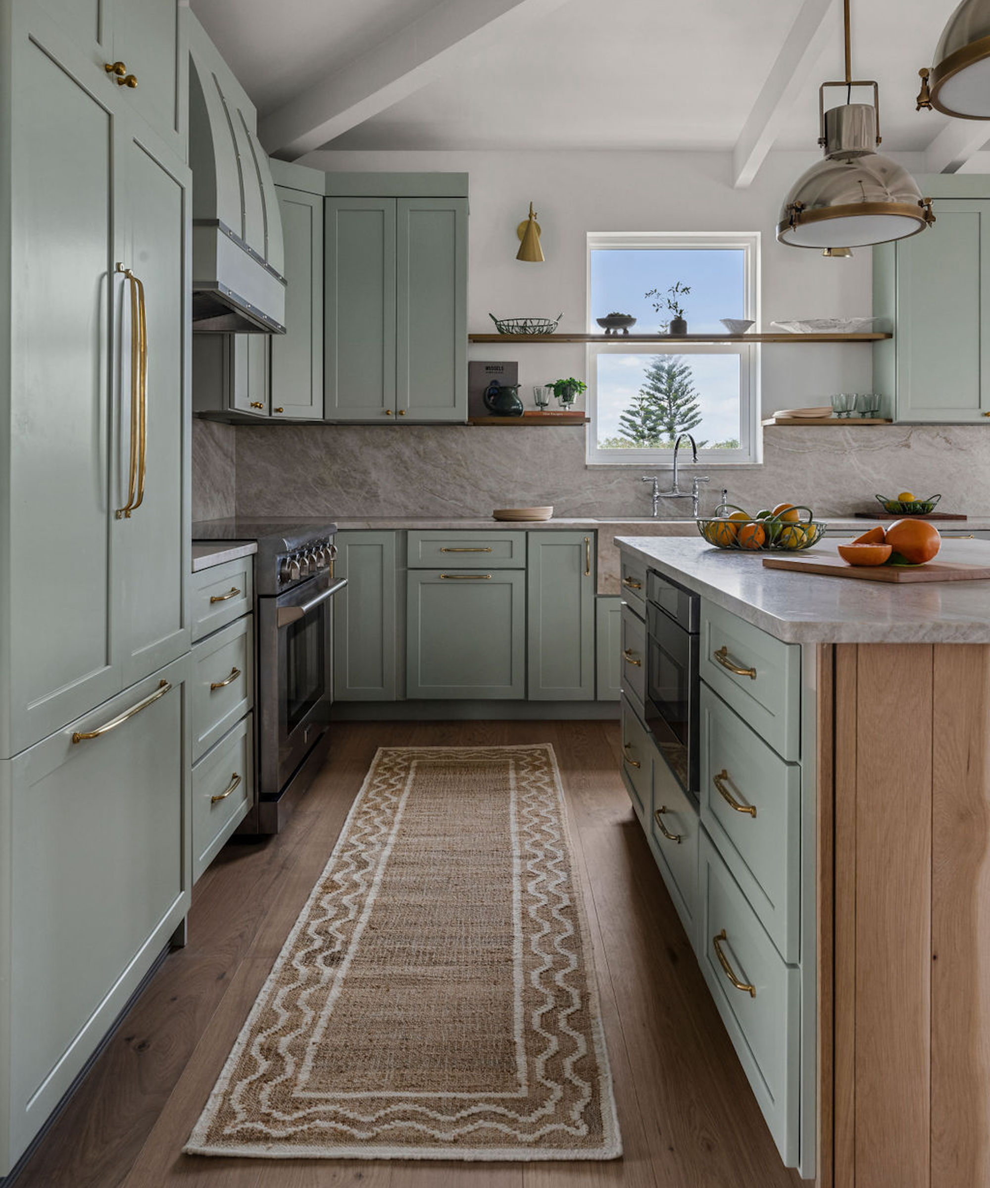 Cuisine avec armoires grises et île, tapis de zone, portée et pendentif au-dessus de l'île