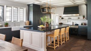 « C’était l’un des projets les plus amusants sur lesquels nous avons travaillé » – 8 leçons de conception pour apprendre de la cuisine grise la plus intéressante que j’ai vue depuis des années Dark gray kitchen with white island and rattan chairs