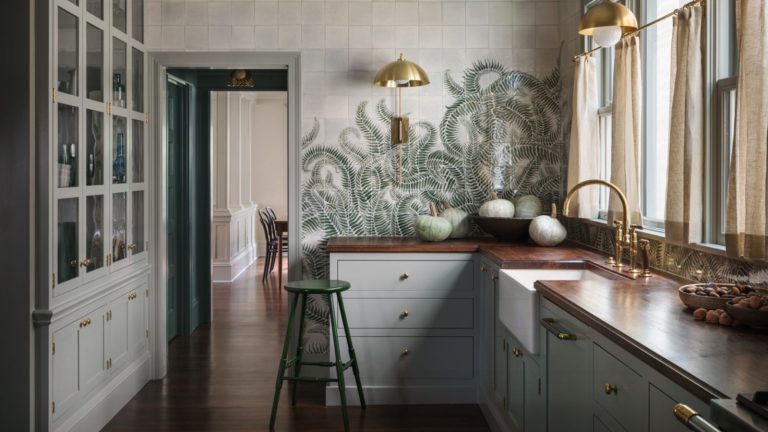 Joanna Gaines partage mon plus grand design Pet Peeve – voici pourquoi vos choix de coulis apparemment sans importance pourraient ruiner vos intérieurs grey green shaker kitchen with dark wooden worktops and green fern printed tile murals