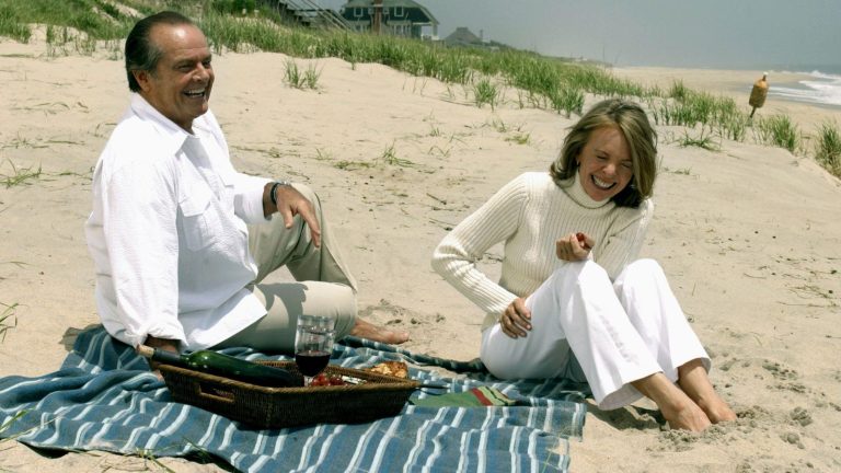 Je n’ai jamais pensé que je pouvais réaliser l’esthétique de Nancy Meyers dans ma petite arrière-cour – jusqu’à ce que je trouve ce patio chic d’Amazon still image from the Nancy Meyers movie Somethings Gotta Give of two characters sat laughing on the beach with a striped towel and picnic
