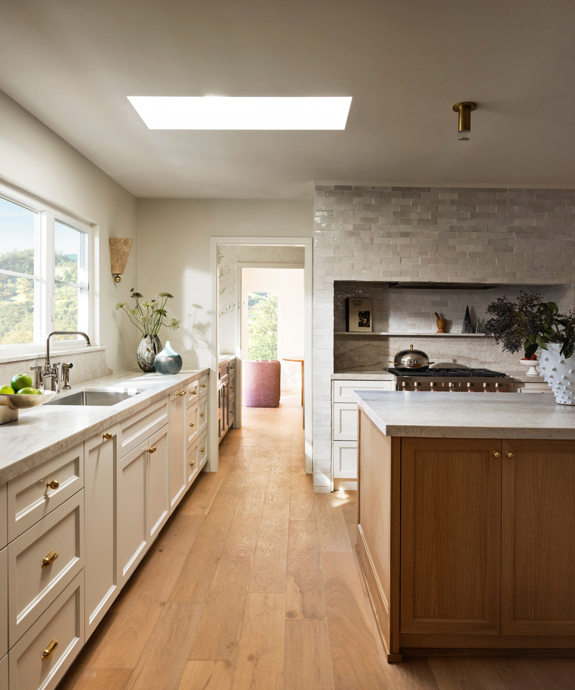 Cuisine neutre avec des murs et des armoires blancs chauds et des planchers de bois