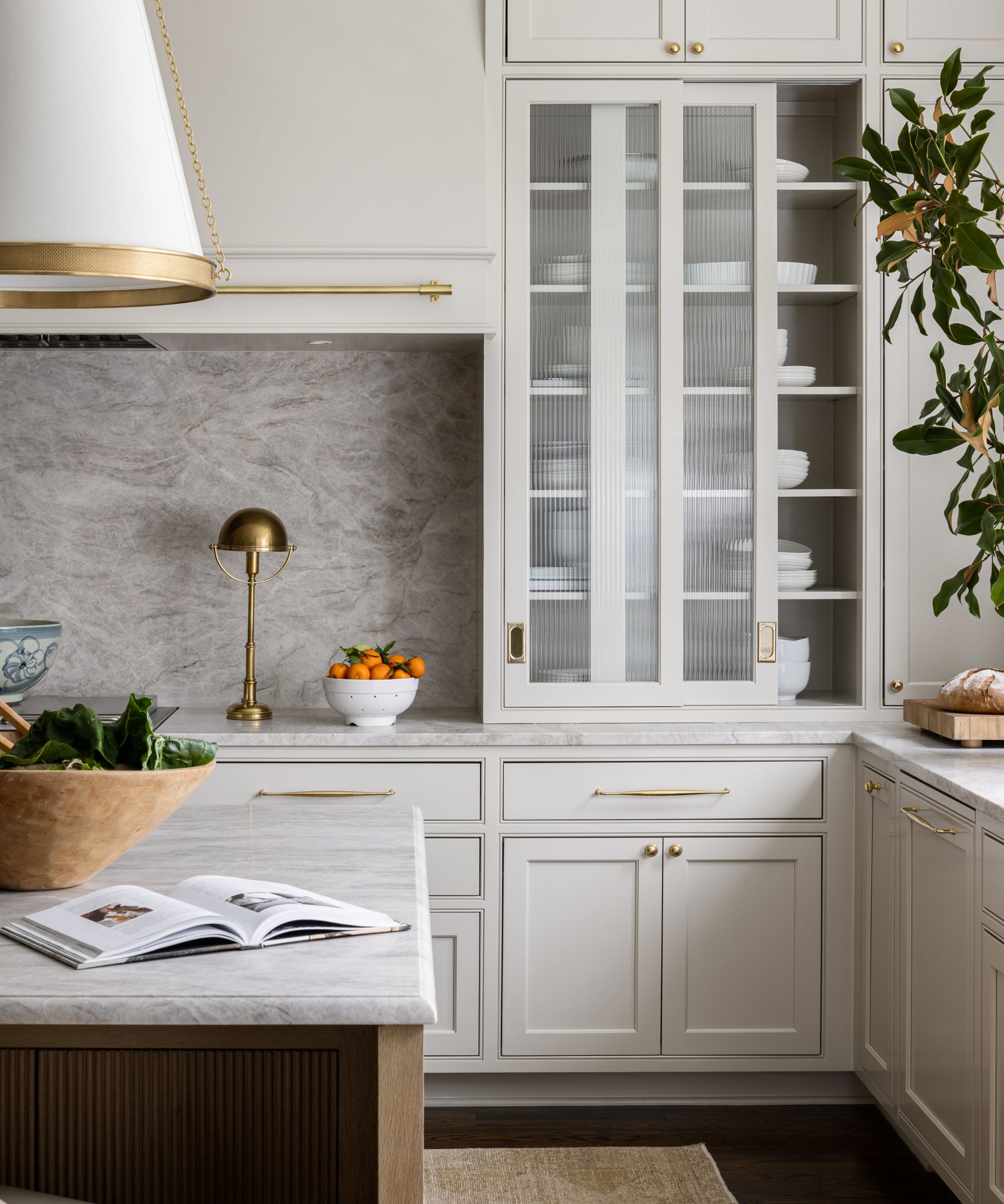 Cuisine moderne avec des armoires gris pâle et du matériel en laiton