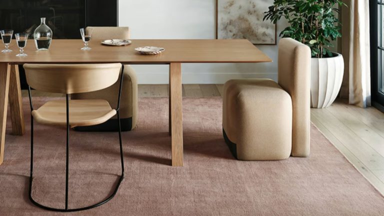 J’ai demandé aux concepteurs ce qu’ils regrettaient d’avoir acheté jusqu’à présent cette année – ce sont les erreurs d’achat en 2025 qu’ils m’ont exhorté à ne pas faire Ashley Tisdale x Rugs USA blush toned wool rug anchors a sleek wooden dining table and modern chair set in a sunlit dining room
