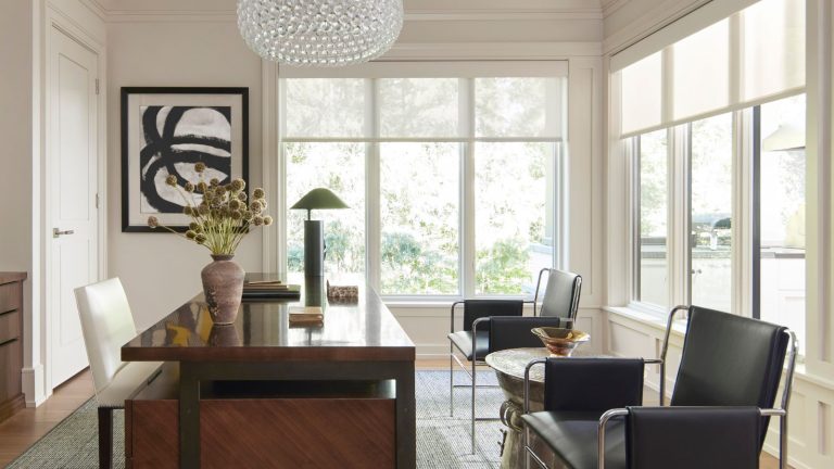 « C’est l’une de ces nuances qui est suffisamment polyvalente pour être utilisée dans toute une maison » – Pourquoi Sherwin-Williams Origami White pourrait être le blanc parfait pour l’intérieur et l’extérieur Home office with white walls, large windows, dark wood desk, midcentury leather metal chairs and abstract art