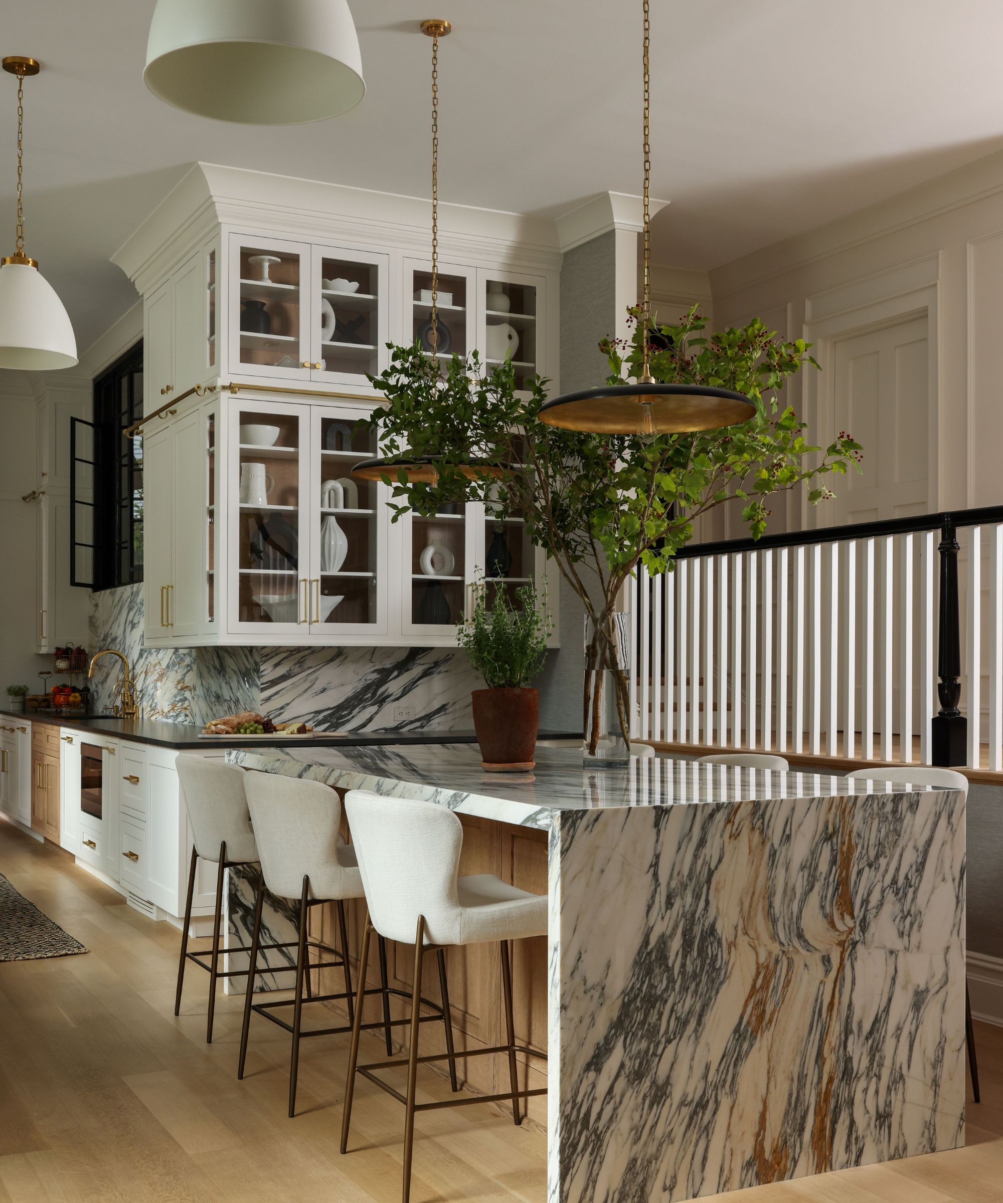 Cuisine blanche avec des tabourets de bar blanc à îlot en marbre