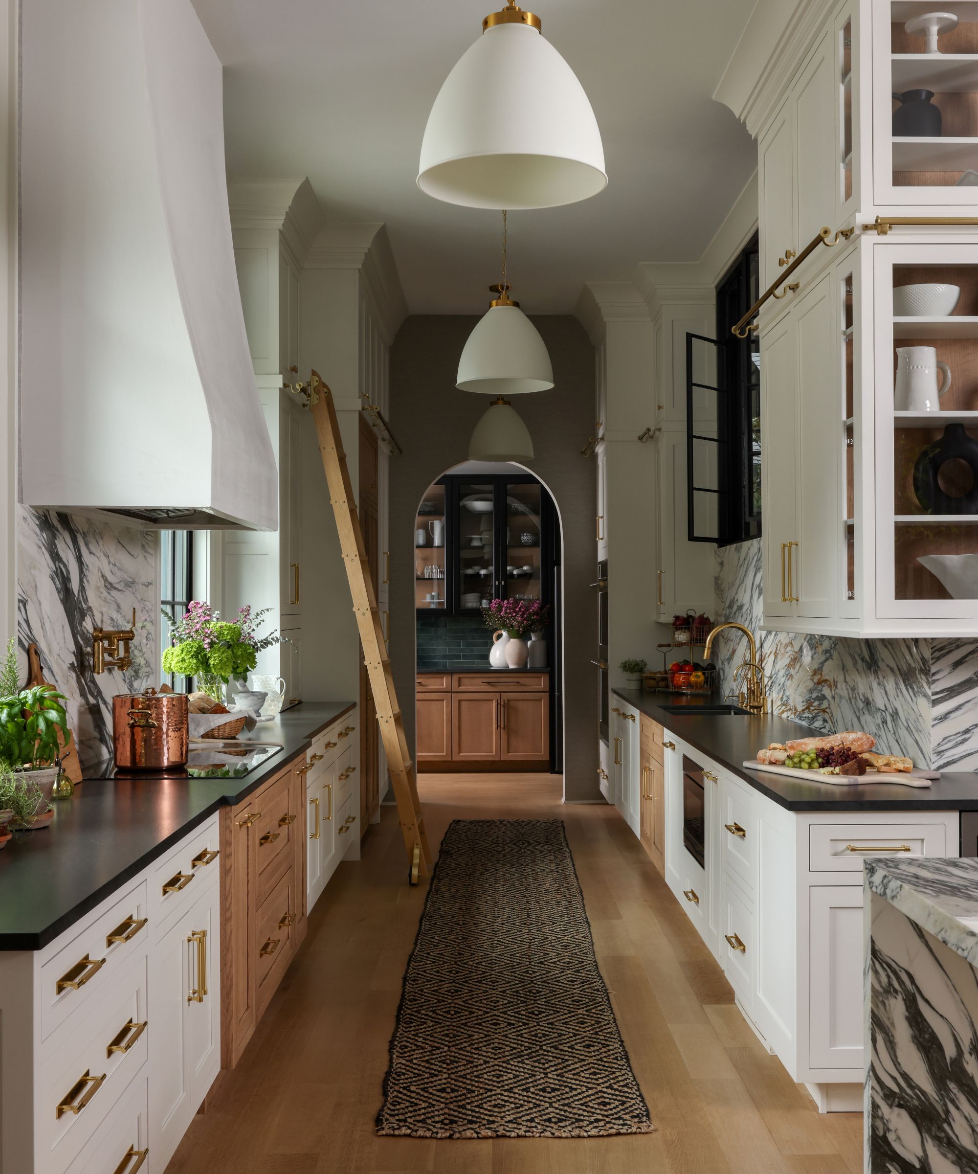 Cuisine blanche avec échelle de bibliothèque et tapis