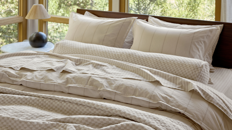 Le nouveau lancement de Parachute cloue l’une des plus grandes tendances de l’été – et cette nouvelle technique innovante le rend encore plus luxueux Beige Parachute yarn-dyed striped bedding photographed on a large bed surrrounded by windows