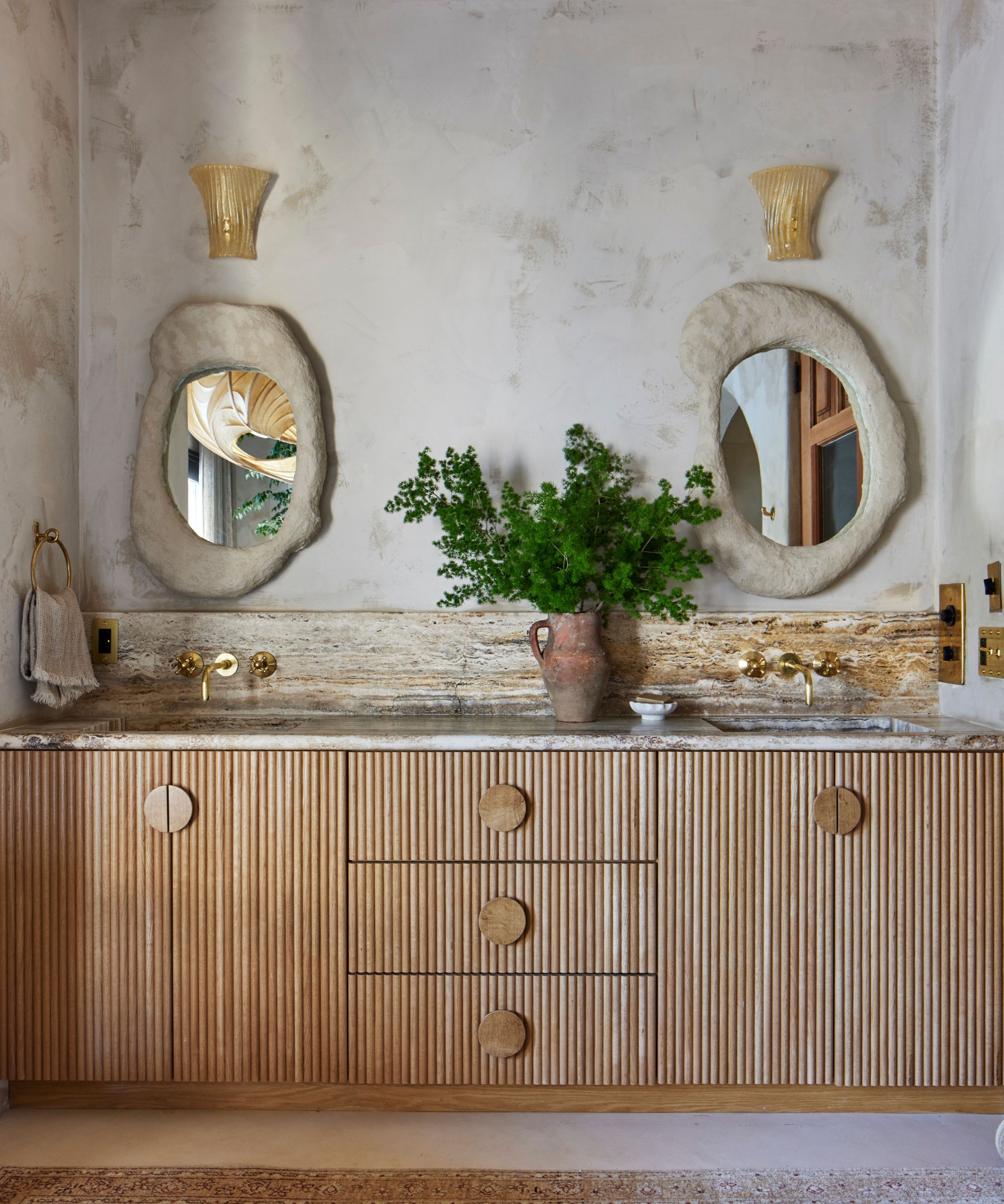 Une salle de bain méditerranéenne avec des murs en plâtre et une vanité de salle de bain en bois