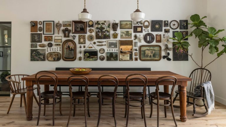 « Les cadres sont de l’art en eux-mêmes » – c’est la seule chose que les concepteurs me disent toujours pour créer une maison plus intéressante avec un budget serré Dining room with long wooden table and bistro chairs and gallery wall with vintage frames and paintings