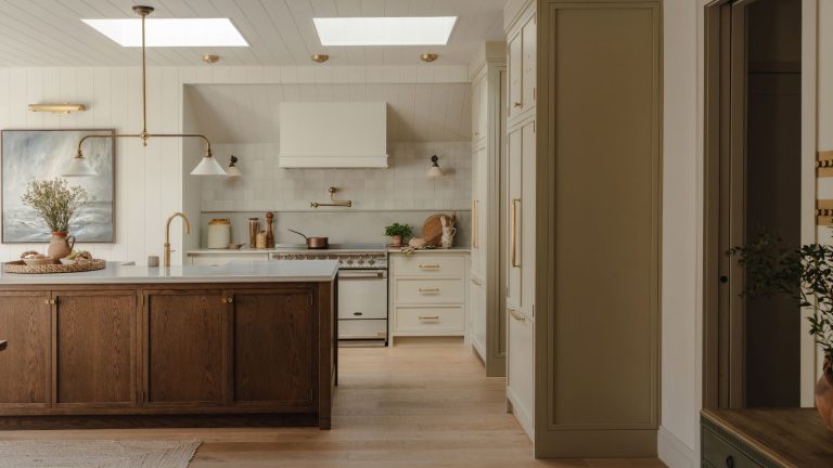 Croyez-moi, les ustensiles de cuisine en bois de mangue sont la 1 chose qui élèvera instantanément la décoration de votre cuisine – c’est chic, intemporel et totalement abordable A large kitchen with cream painted cabinets and a large wooden cabinet island.