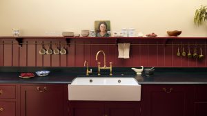Bye bye carrelé des dosserets, toutes les cuisines les plus personnalisées que je vois en ce moment présentent ce design à l’ancienne à la place A burgundy and beige kitchen with black countertops and a paneled kitchen backsplash