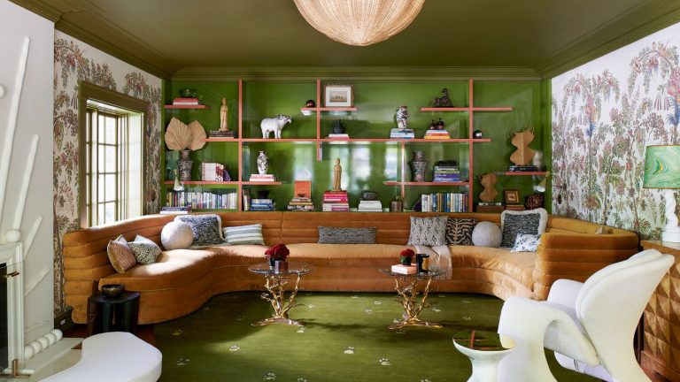 Avez-vous entendu parler de Dill Green? Les concepteurs appellent ce vert tendance «Nature’s Neutral» et il est étonnamment facile à utiliser Living room with green painted ceiling and wall, open shelving, wallpaper mural, green rug and large U-shaped brown sofa with modern armchair and two ornate iron side tables