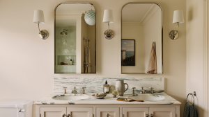 8 petites idées de vanité de salle de bain qui prouvent que les dessins compacts peuvent être tout aussi élégants a bathroom with a double vanity, two mirrors, three wall sconces, and various bathroom necessities on the countertop