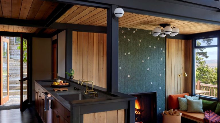 Les murs de caractéristiques peuvent être un faux pas de conception, mais des cheminées en fonction? Les concepteurs approuvent définitivement cette tendance de déclaration qui élève une pièce confortable Wood panelled kitchen and living room with tiled fireplace mural, and window seat