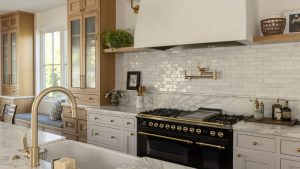 Les designers d’intérieur prédisent que ces 11 tendances de comptoir de cuisine seront partout en 2026 A neutral kitchen with a tiled backsplash and natural stone countertops