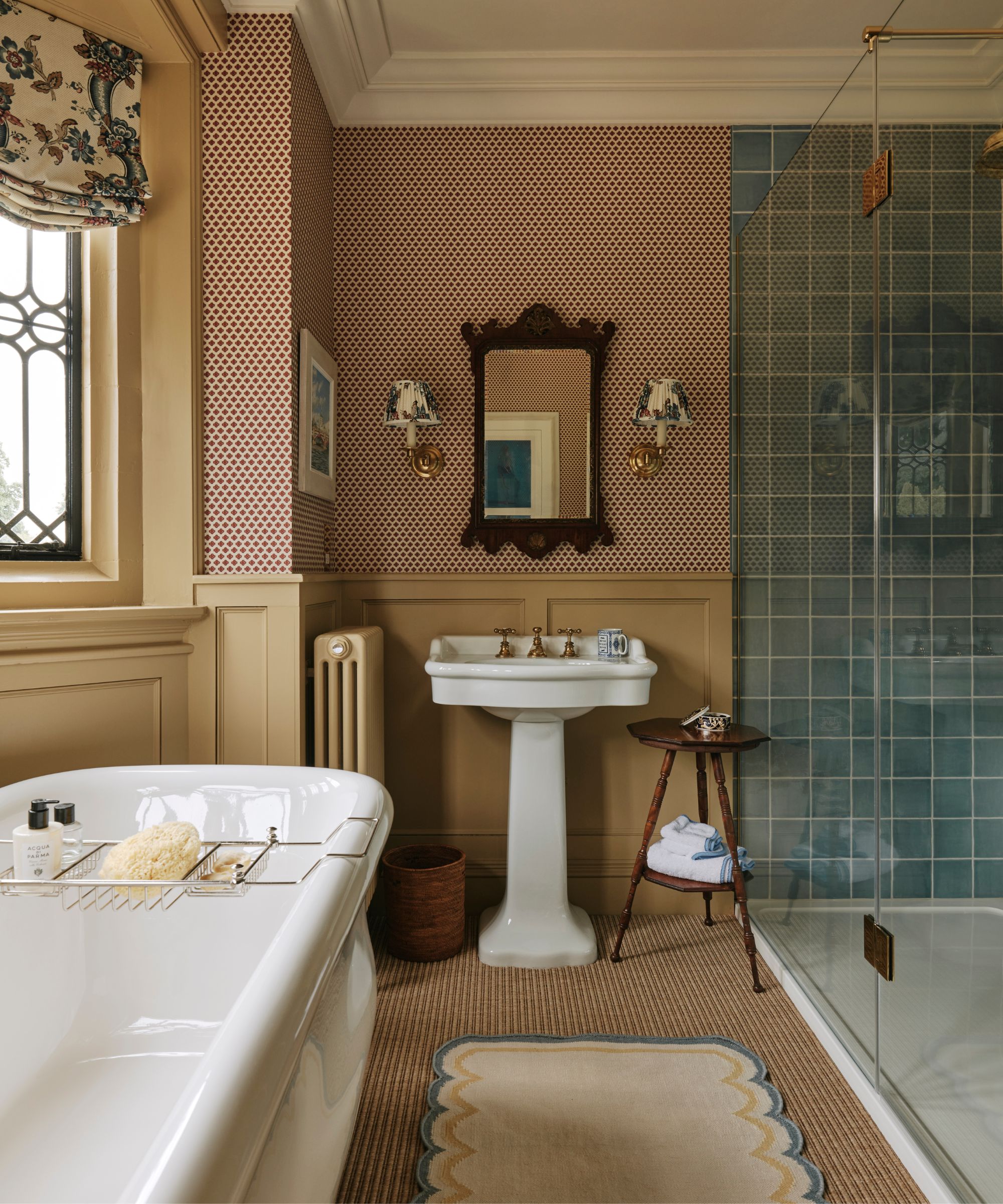 Salle de bain avec bourse jaune et cadre de fenêtre, papier peint à pois, douche carrelée bleue, tapis de jute, évier à piéde et baignoire