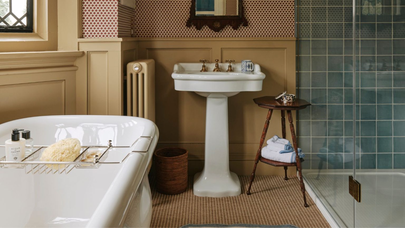 Je ne peux pas croire que je dis cela, mais la salle de bain moquette fait-elle un retour? Les concepteurs révèlent si ce style daté peut fonctionner en 2025 Bathroom with butter yellow panelling, pedestal sink, blue tiled shower, wooden side table and bath with rack