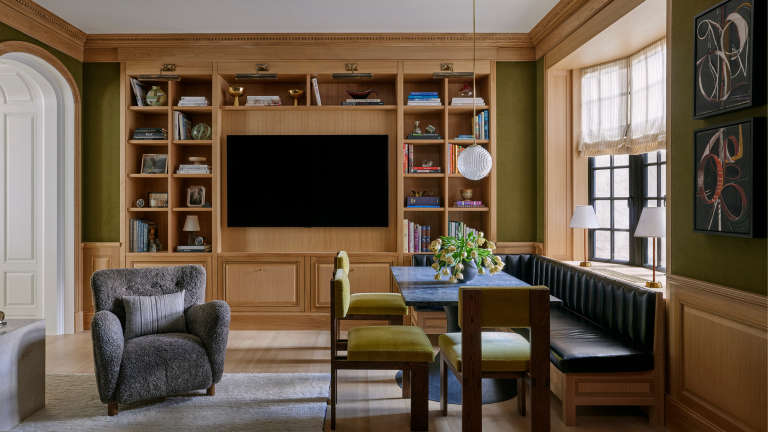« Je reçois des SMS du propriétaire en disant qu’elle continue de se pincer » – comment cette équipe de conception a assoupli une disposition formelle des années 30 pour créer un appartement en couches et habitables de l’Upper East Side A reimagined formal dining room is now a relaxed family room with a built-in breakfast nook, a wooden bookshelf, and eclectic furnishing.