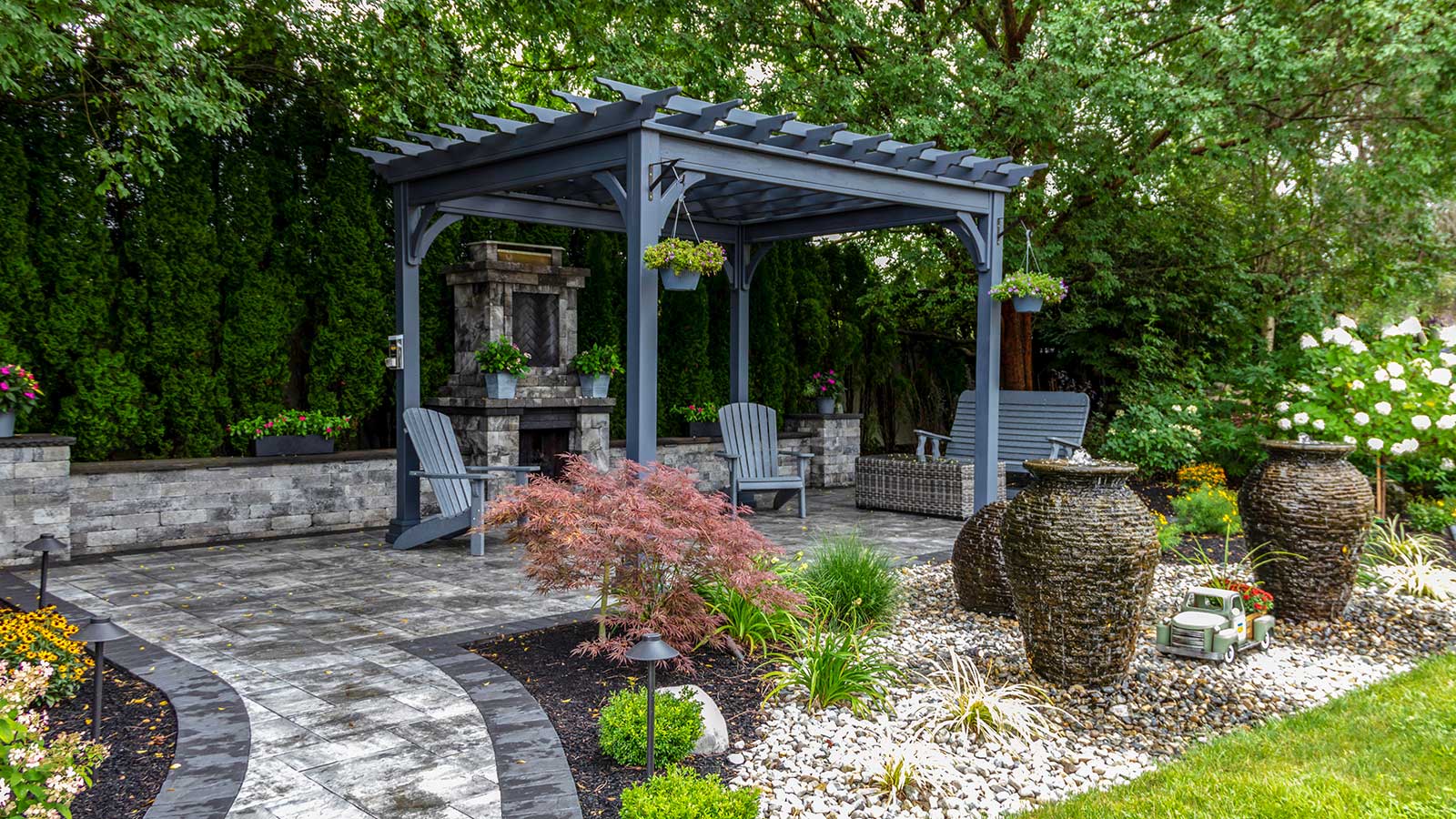 Pergola sur patio avec aménagement paysager de gravier et fontaines