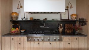 C’est le seul matériau que les concepteurs choisissent plutôt que le marbre en 2026 A kitchen with white walls, paneled wooden cabinetry, and granite countertops