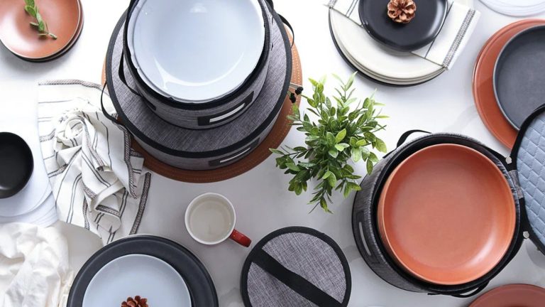 N’attendez pas après Thanksgiving – Cet ensemble de rangement de vaisselle chic à 44 $ est le moyen le plus simple de protéger vos plats de vacances et d’économiser de l’espace toute l’année. A set of gray hard shell dinnerware storage with crockery on a white table, viewed from above.
