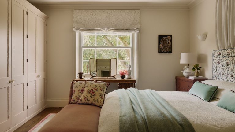 Réchauffez les pièces orientées au nord avec un « refroidissement humide » avant de vous coucher avec un déshumidificateur, révèlent des professionnels du CVC A traditional country bedroom, with built-in closets along one wall, and a bed opposite. On the far wall, a wooden dressing table is against a framed window.