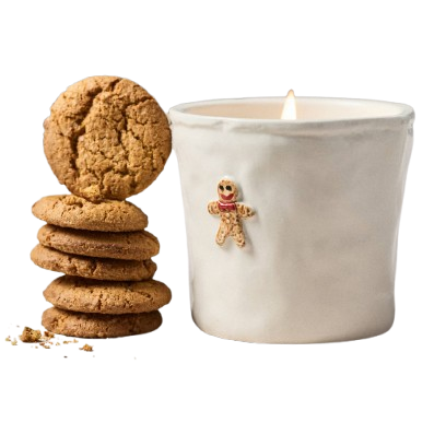 Une bougie en pain d'épice avec des biscuits en pain d'épice empilés à côté