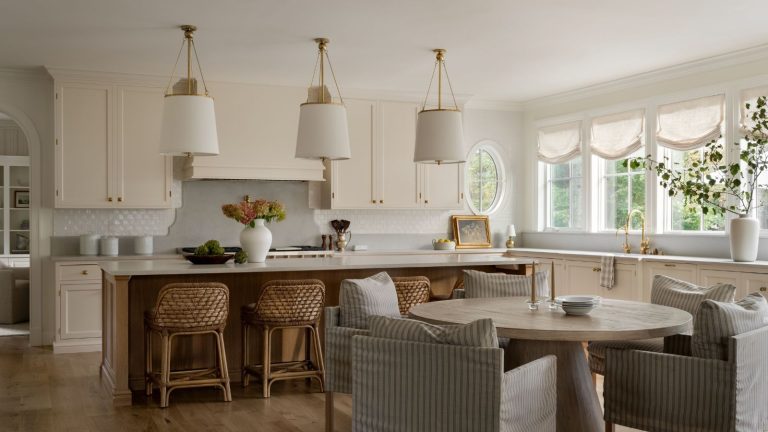 « Cela semble intemporel mais sur mesure, enraciné dans la tradition mais conçu pour la vie de tous les jours » – Découvrez le dernier remodelage de la cuisine de Shea McGee qui est une leçon sur son nouveau style patrimonial A neutral kitchen with warm white cabinets, a wooden island, and curved profiles throughout the design