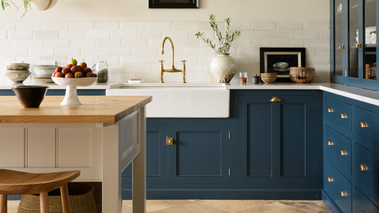 Je redoutais les avalanches d’armoires de cuisine jusqu’à ce que j’achète cet organisateur à 22 $ – je peux maintenant trouver ce que je cherche sans chaos White kitchen with dark blue deVOL cabinets, wooden floors and wooden island with white sides and basket storage underneath
