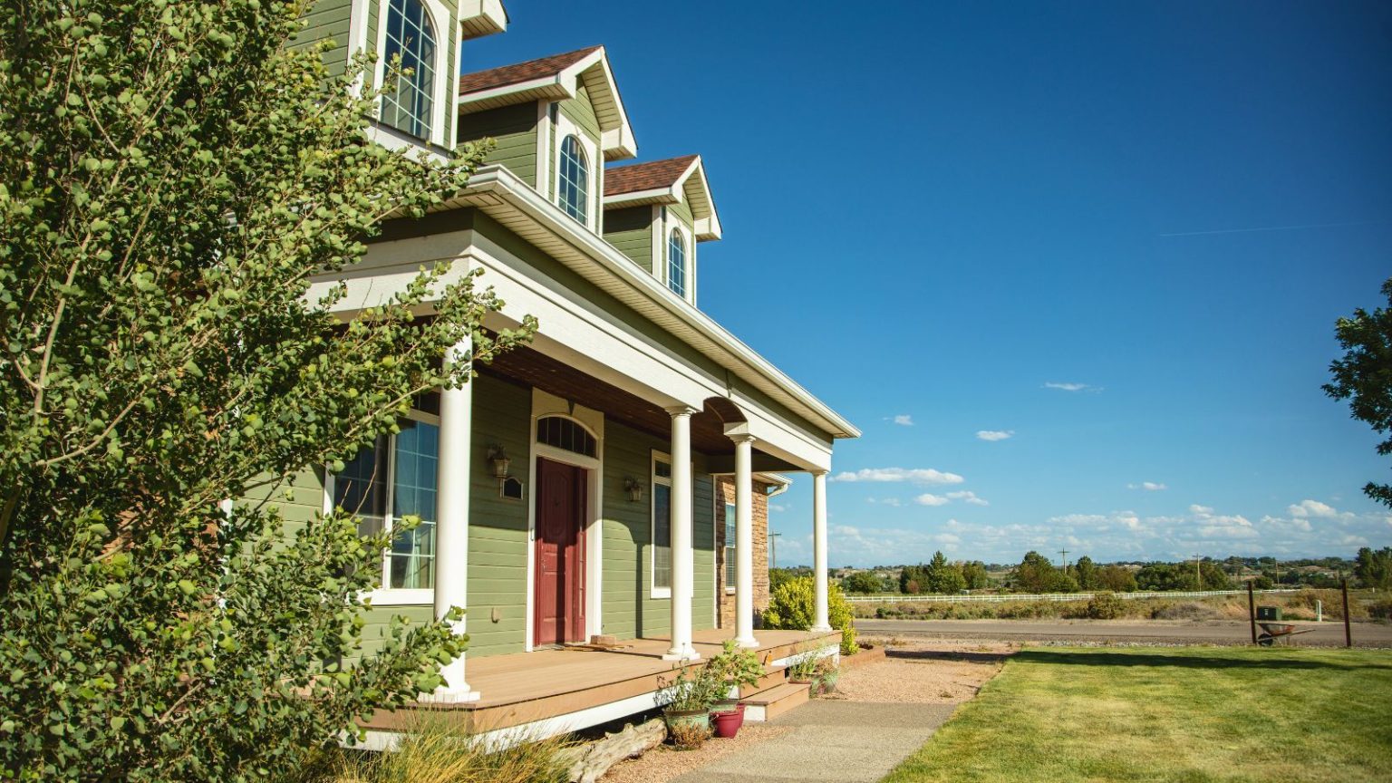 Si vous n’effectuez qu’une seule tâche d’entretien cet automne, donnez un peu d’attention à vos gouttières – cet outil à 19 $ le rend plus rapide et plus facile. A green painted suburban American home with a lawned front yard, and a view of fields and trees.