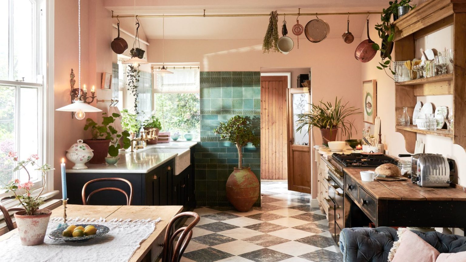 Oubliez de tremper votre éponge de cuisine dans de l’eau de Javel ou de la passer au micro-ondes : je suis un nettoyeur professionnel et c’est le moyen le plus simple de bannir complètement les bactéries. Peach kitchen with checkered floor and pot hanging rail. Green cabinets and butler sink on left, with wooden counters on the rights and mounted shelving