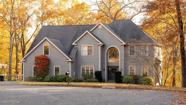 A front view of a beautiful American house and autumn leaves in the background