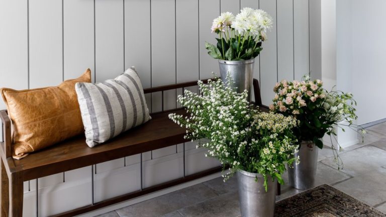 Nulle part où s’asseoir dans votre petite entrée ? Économisez 210 $ sur ce rangement d’entrée Wayfair chic avec banc Small entryway with wooden paneled walls painted off white, with wooden bench and metal vases of white flowers