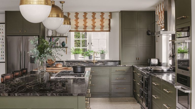 9 joyaux de rangement chics pour le garde-manger de cuisine que nos rédacteurs maison s’approprient du magasin de conteneurs pour apprivoiser le chaos festif – et ils sont déjà en vente A large green painted kitchen with island. Black marble worktops.