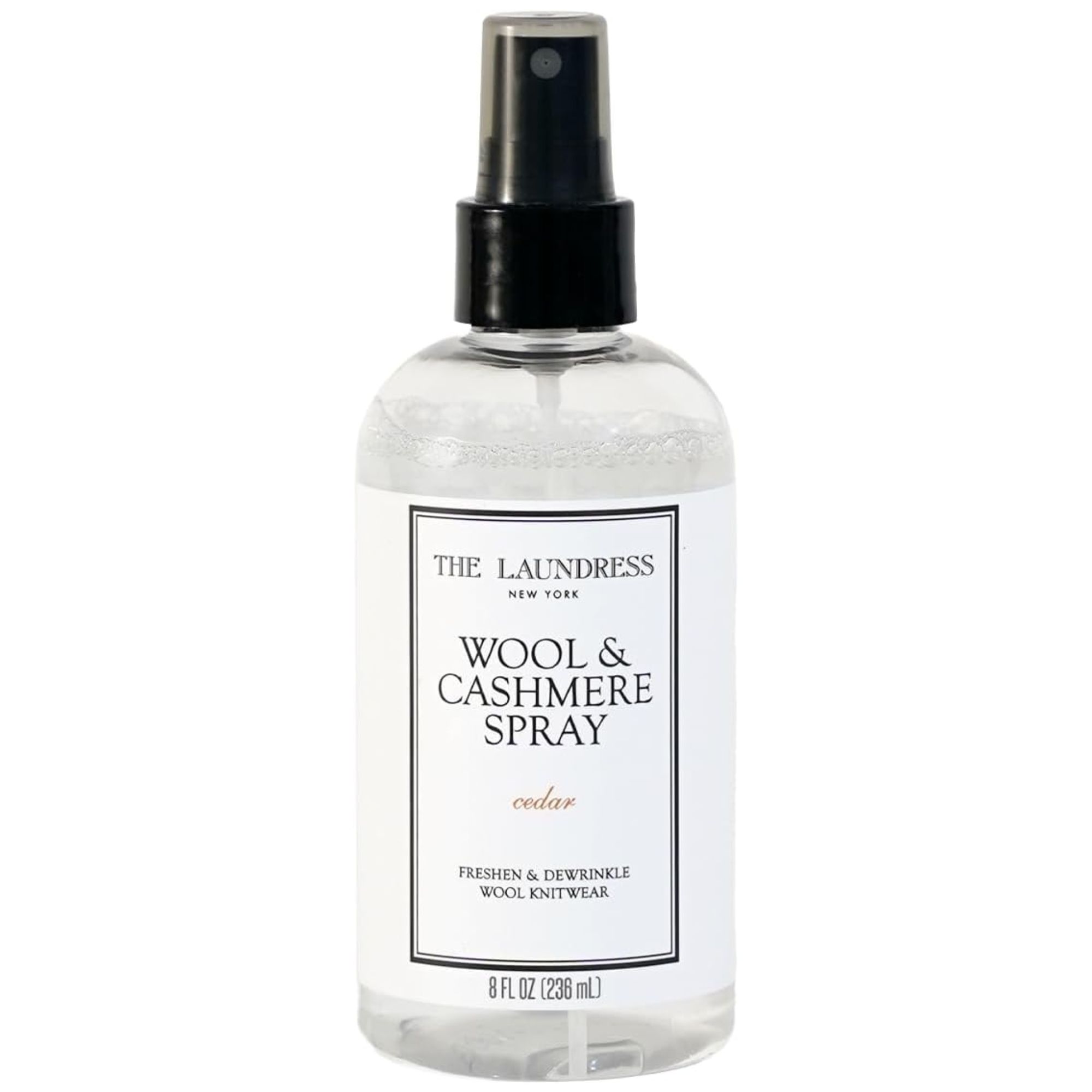 Une bouteille en plastique transparent de The Laundress Wool &amp; Spray cachemire avec une étiquette blanche et noire et un couvercle spray noir