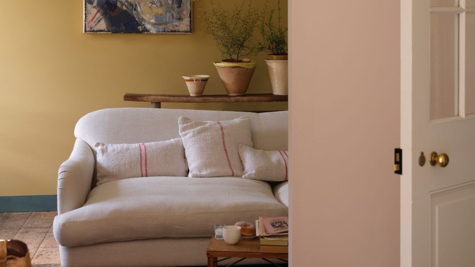 J’en avais marre des courants d’air froids dans les portes d’entrée qui donnaient à mon salon une sensation arctique et faisaient grimper les coûts énergétiques – Une solution Amazon facile à 4 $ a changé la donne Living room with muted yellow walls, cream sofa and wooden floors